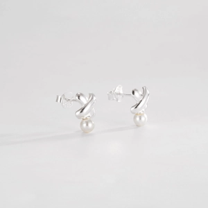Detail of S925 sterling silver cross earrings with round white pearl pendant