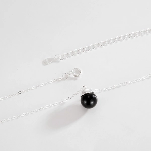 Detail of S925 sterling silver chain with black agate bead and engraved logo tag