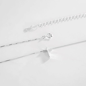Detailed macro of S925 sterling silver cross pendant with spring ring clasp and hallmark