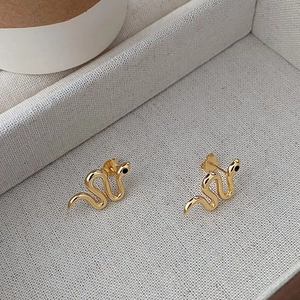 Detailed close-up of golden S925 sterling silver snake earrings with black eye accents