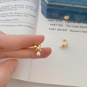 French vintage gold cross pearl earrings with S925 silver studs on a book background