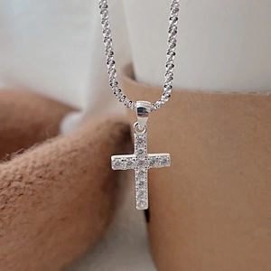 Detailed shot of S925 sterling silver cross pendant with sparkling zircon inlays