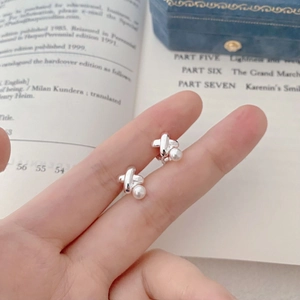 Macro detail of French vintage cross earrings with S925 silver finish and pearl drop inlay