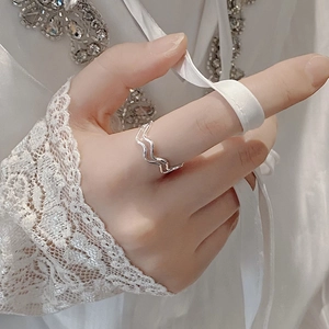 Detail of 925 sterling silver double wave ring on hand with elegant ribbon background