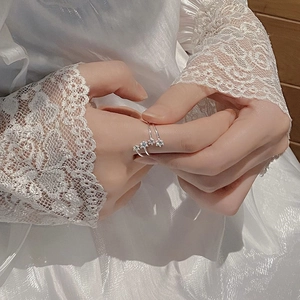 Detail of S925 sterling silver star rings with zircons on elegant lace background