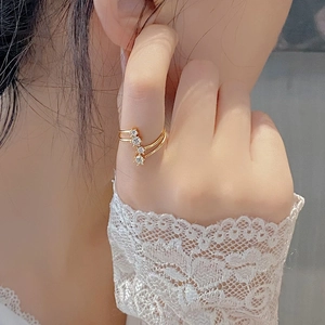 Close-up of a double-layered gold star ring with sparkling cubic zirconia on a finger