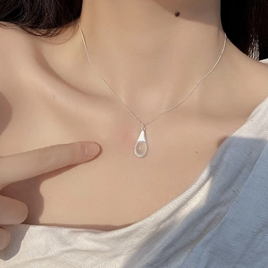 Close-up of S925 silver necklace with teardrop pendant and moonstone on neck