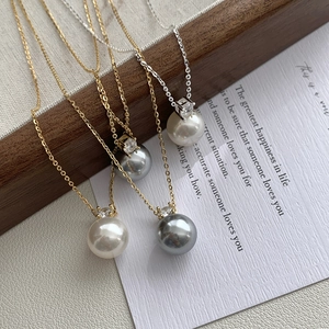 Detail of round pearl necklaces with zircon accents on gold and silver chains