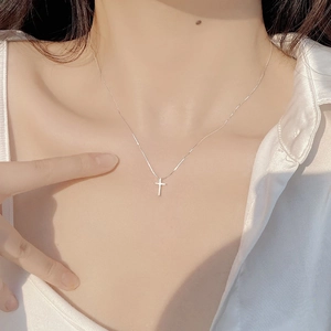 Elegant S925 sterling silver cross necklace worn by model on a minimalist background