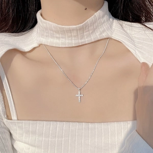 Elegant S925 sterling silver cross necklace with sparkling crystals worn by a model