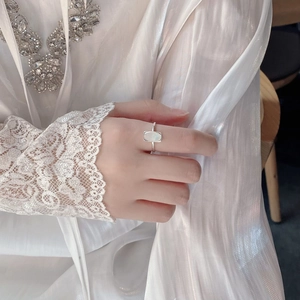 Detail of S925 sterling silver ring with oval white shell on model with lace sleeve