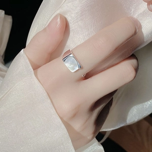 Detailed view of an adjustable silver ring featuring a rectangular white shell inlay