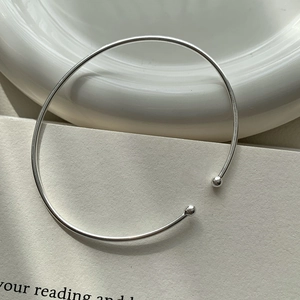 Detail of minimalist S925 sterling silver open bead bracelet on ceramic display