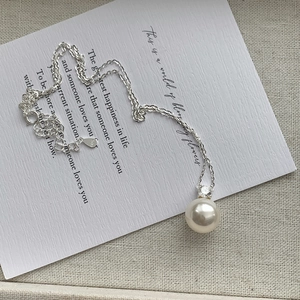 Detail view of S925 sterling silver stamp on white pearl necklace with zircon accent