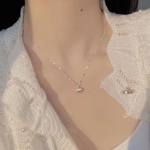 Close-up of a brushed S925 sterling silver heart pendant necklace on a neck model