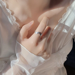 Detailed view of an adjustable S925 sterling silver wavy ring on a female finger