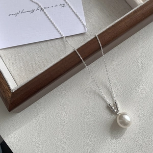 Detailed close-up of a large white shell pearl pendant on a S925 sterling silver chain