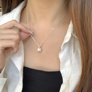 Elegant S925 sterling silver necklace featuring a round white pearl pendant worn on neck