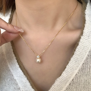 Close-up of S925 sterling silver gold chain with a round pearl and sparkling zircon stone