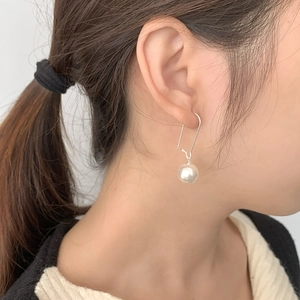Gros plan de boucles d'oreilles en argent S925 avec perles synthétiques blanches