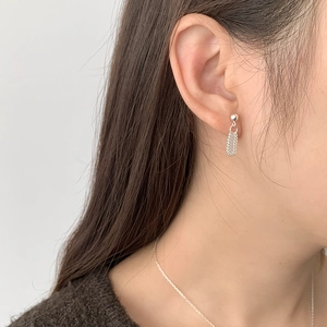 Detail of S925 silver beaded tassel earring with woven texture shown on a model
