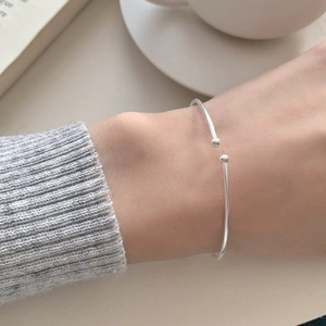 Close-up of minimalist S925 sterling silver open bead bracelet on a female wrist
