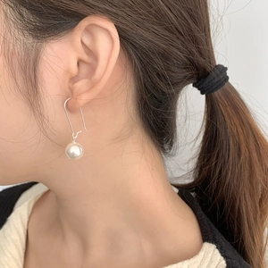 Détail d'une boucle d'oreille en argent S925 avec long crochet et perle blanche ronde