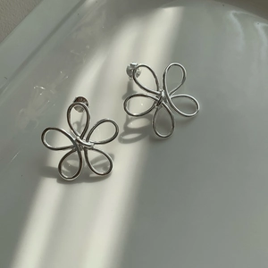 Macro shot of S925 sterling silver stamp on minimalist hollow flower stud earrings
