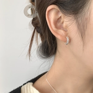 Minimalist 925 sterling silver hoop earrings with spiked texture on female model