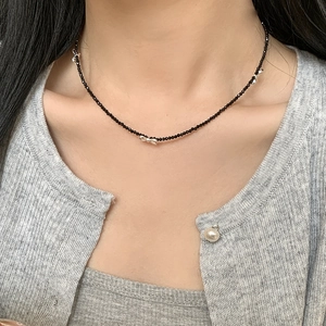 Detail of S925 silver bow pendant with black spinel beads on a female model
