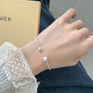 Minimalist S925 sterling silver twist bangle featuring polished double beads on model
