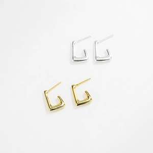 Minimalist geometric J-shape earrings in polished gold and silver finishes on white