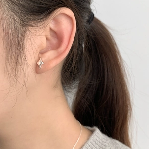 Close-up of minimalist S925 sterling silver star stud earring worn on model ear