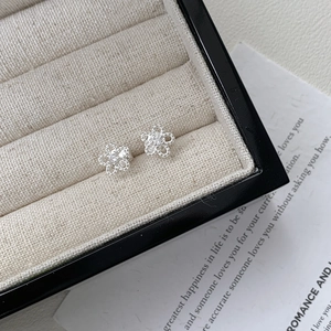 Macro detail of S925 sterling silver hollow flower studs with crystal center