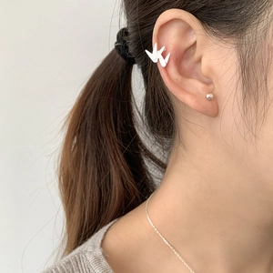 Détail d'un ear cuff feuille de bambou en argent 925 et d'une puce géométrique