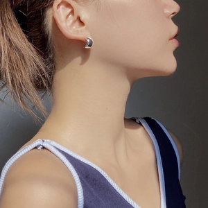 Close-up of a polished S925 silver C-shaped earring worn by a model in a minimal style