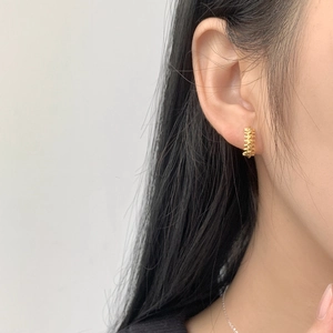 Close-up of 925 sterling silver gold-plated hoop earrings with textured stud design