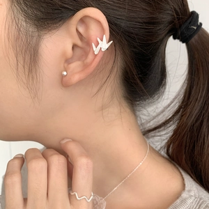 Détail du clip d'oreille en argent 925 avec design grue origami sur une oreille