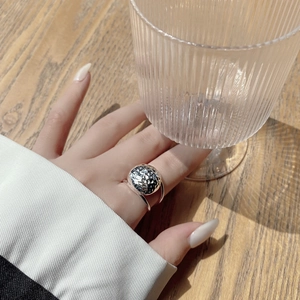 Detail of S925 sterling silver ring with handmade hammered texture on a circular surface