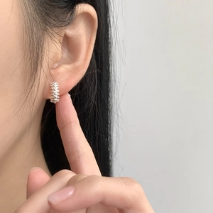 Detailed close-up of 925 sterling silver hoop earring with unique spine gear texture