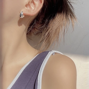 Modern silver water drop earrings in a minimalist streamlined design worn by a model