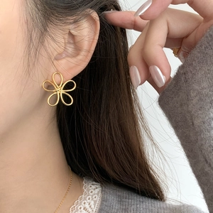 Elegant gold hollow flower stud earrings in S925 sterling silver worn by a model