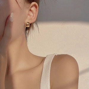 Close-up of minimalist gold S925 silver C-shape hoop earring worn by a model