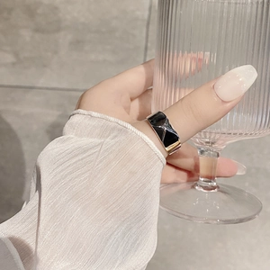 Detailed view of a silver-toned quilted pattern ring with black enamel finish on hand