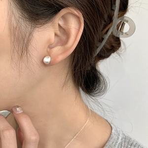 Close-up of minimalist S925 sterling silver brushed teardrop studs on ear