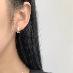 Macro view of 925 sterling silver hoop earrings with minimalist spiked spine texture