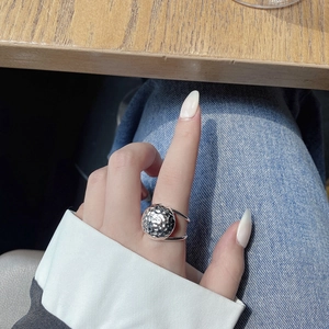 Detail of S925 sterling silver hammered texture ring worn on hand with blue jeans
