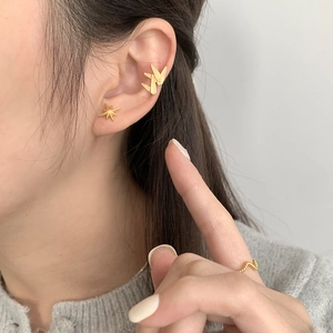 Gros plan d'une manchette d'oreille feuille de bambou dorée et puce étoile