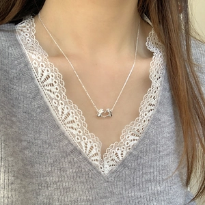 Close-up of S925 sterling silver necklace with heart hand gesture pendant on model