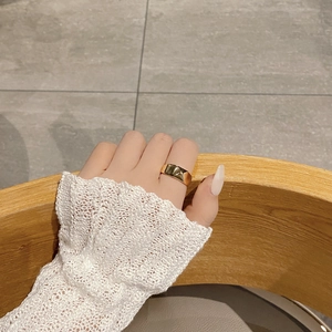 Detailed view of wide gold rhombus ring with star engraving on finger of woman